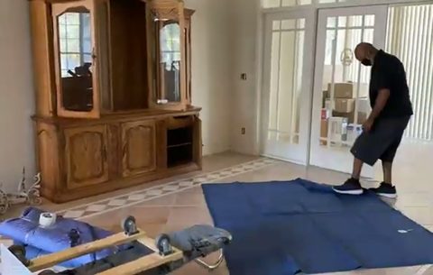 mover preparing to move a glass display cabinet with dolly and moving pads